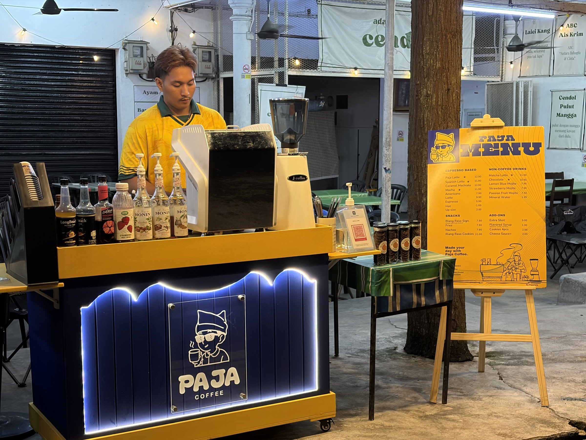 Barista at the PajaCoffee kiosk in the evening